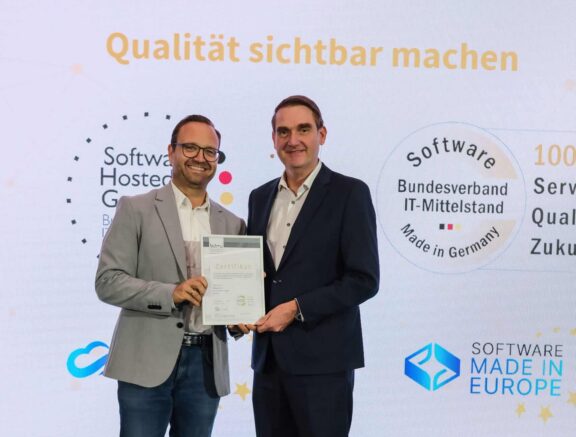 Christoph Adamczyk bei Preisverleihung mit Zertifikat, itdesign Logo im Hintergrund.