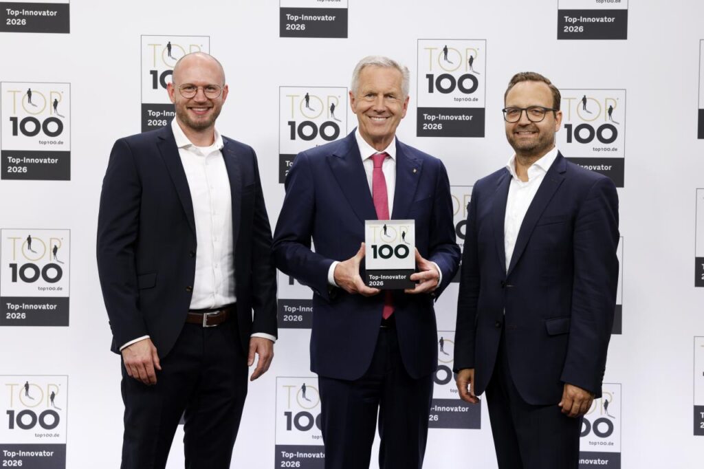 Felix Zwießele und Christoph Adamczyk nehmen den "Top 100"-Award von Christian Wulff entgegen.